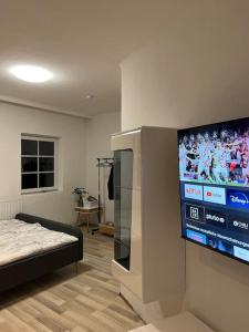 une pièce avec une télévision à écran plat sur un mur dans l'établissement Modernes Haus nähe Schloss Ulmerfeld, à Ulmerfeld