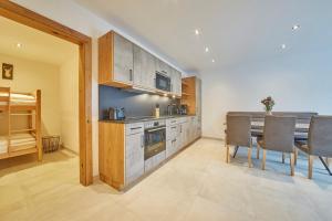 a kitchen with a table and chairs in a room at Appartement Atzingerberg in Maishofen