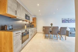 een keuken met een tafel en stoelen in een kamer bij Appartement Atzingerberg in Maishofen