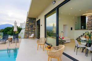 - un salon avec vue sur une maison dans l'établissement Majestic View Villas, à Agios Nikolaos