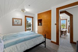 a bedroom with a large bed and a table at The Professor's Beach House - Brighton Home in Mosgiel