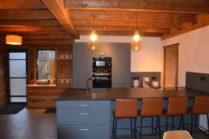 a kitchen with a large island with bar chairs at A la cheneau in Rochesson