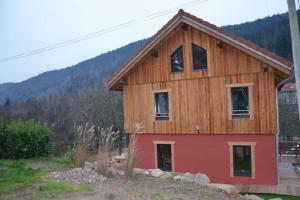 a wooden house with a red bottom at A la cheneau in Rochesson