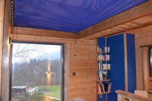 Cette chambre est dotée d'un plafond bleu et d'une fenêtre. dans l'établissement A la cheneau, à Rochesson