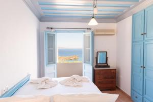 a bedroom with a bed and a view of the ocean at Patmos Exclusive Villas in Skala