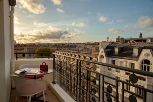 a balcony with a table and a view of a city at Villa Marquis Member of Meliá Collection in Paris