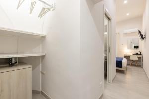 une cuisine aux murs blancs et une porte menant à une chambre. dans l'établissement La Torre 31, à Formia
