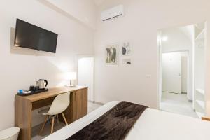- une chambre avec un lit et un bureau avec une télévision dans l'établissement La Torre 31, à Formia