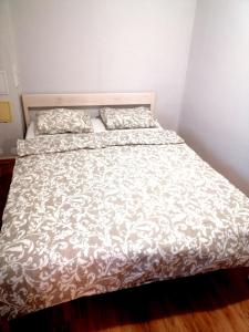 Bett mit weißer Tagesdecke und 2 Kissen in der Unterkunft apartmaji Renc in Renče