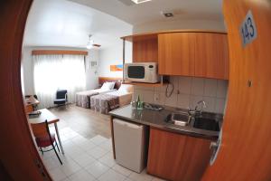a kitchen and a living room with a bed at Union Residence - HEER in Novo Hamburgo