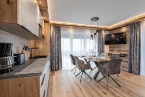 uma cozinha e sala de jantar com mesa e cadeiras em Apartment NH96 inklusive kostenfreiem Eintritt in die Alpentherme em Bad Hofgastein