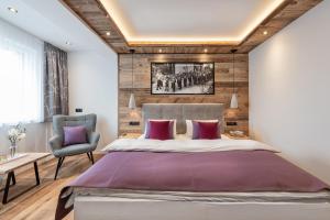 sypialnia z dużym łóżkiem i krzesłem w obiekcie Apartment NH96 inklusive kostenfreiem Eintritt in die Alpentherme w mieście Bad Hofgastein +37 zdjęć