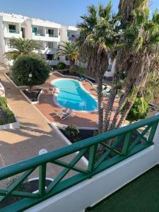 een balkon met uitzicht op een zwembad bij Coqueto apartamento ZUA con piscina in Costa Teguise