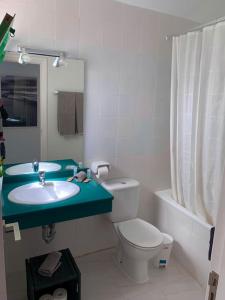 een badkamer met een wastafel, een toilet en een douche bij Coqueto apartamento ZUA con piscina in Costa Teguise