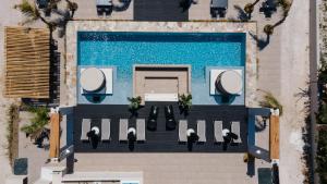 una vista aérea de una piscina con gente sentada a su alrededor en Eden Beachfront Residences & Suites en Kastraki