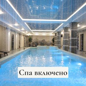 - une grande piscine d'eau bleue dans un bâtiment dans l'établissement GasthauS & SPA, à Bukovel