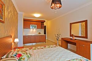 a bedroom with a large bed and a kitchen at Boutique Rose Gardens Pomorie in Pomorie