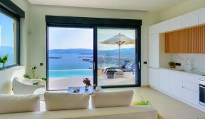 un soggiorno con divano e vista sull'oceano di Majestic View Villas ad Ágios Nikólaos