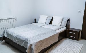 Vila Carolina Apulum في ألبا يوليا: سرير بشرشف ووسائد بيضاء في الغرفة