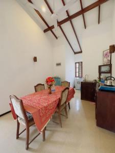 a dining room with a table and some chairs at Royal beach villa in Unawatuna