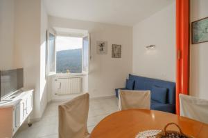 ein Esszimmer mit einem Tisch und einem blauen Sofa in der Unterkunft Casavacanze delle Noci in Marciana