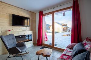 Cosy Cottage 1800 - pied des pistes - Piscine, Sauna, parking privée في ليه أورس: غرفة معيشة مع موقد وتلفزيون