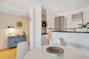 - une cuisine avec une table blanche et des chaises blanches dans l'établissement Precioso apartamento en La Nogalera - Vista al mar, à Torremolinos