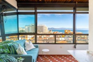 - un salon avec un canapé et une grande fenêtre dans l'établissement Precioso apartamento en La Nogalera - Vista al mar, à Torremolinos
