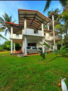 Royal beach villa في يوناواتونا: منزل فيه سيارة متوقفة أمامه