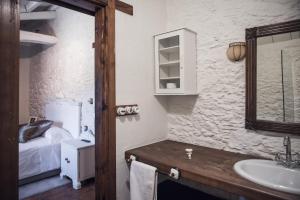 a bathroom with a sink and a mirror and a bed at Houmi A Ponte in Boimorto +20 photos