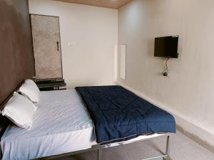 a bedroom with a bed and a tv on the wall at HOTEL ROYAL INN in Satna