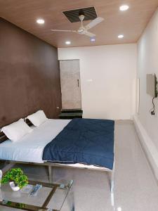 HOTEL ROYAL INN في Satna: غرفة نوم بسرير وطاولة زجاجية