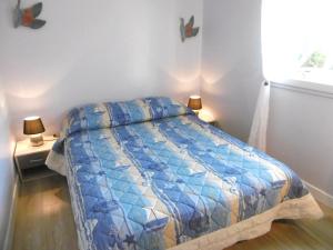 - une chambre avec un lit et une couette bleue dans l'établissement Maisonnette Katell, à Sarzeau