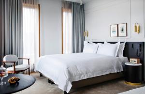 a bedroom with a large white bed and a table at Pillows Grand Boutique Hotel Maurits at the Park - Small Luxury Hotels in Amsterdam