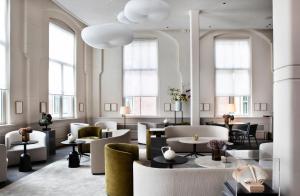 a lobby with tables and chairs and windows at Pillows Grand Boutique Hotel Maurits at the Park - Small Luxury Hotels in Amsterdam