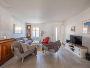 a living room with a couch and a tv at Jolie maison familiale a Saint Clement des Baleines in Saint-Clément-des-Baleines