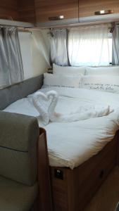 a large bed with a white blanket on it at שלווה בים - צימר ים המלח, deadsea in Ovnat