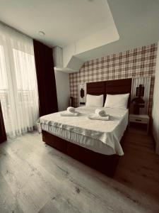 um quarto com uma cama grande e lençóis brancos em Hotel Innception em Colónia