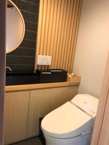 bagno con servizi igienici bianchi e specchio di 一日一組限定 古民家の宿 勝右衛門 御所 a Gose