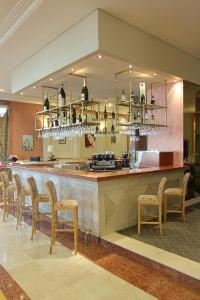 un ristorante con un bar con un mucchio di sedie di Lucania Palazzo Hotel a Comodoro Rivadavia