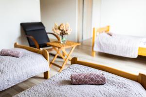 1 dormitorio con 2 camas y mesa con silla en Rodzinny apartament FOLKER, en Cisiec