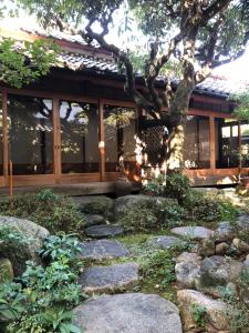 un giardino con rocce di fronte a un edificio di 一日一組限定 古民家の宿 勝右衛門 御所 a Gose