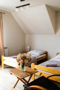 um quarto com uma mesa com um vaso de flores em Rodzinny apartament FOLKER em Cisiec