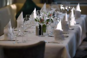 einen langen Tisch mit Weingläsern und weißen Servietten in der Unterkunft Gasthof Kreuz in Bad Waldsee