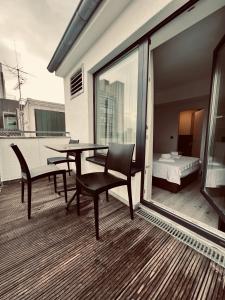 einen Balkon mit einem Tisch und Stühlen sowie ein Schlafzimmer in der Unterkunft Hotel Innception in Köln