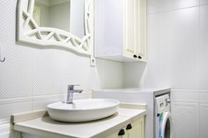 een witte badkamer met een wastafel en een spiegel bij Flat Close to Beach in Karsiyaka in Izmir