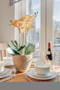 a table with plates and a plant and a bottle of wine at Cosy countryside apartment in Wellingborough
