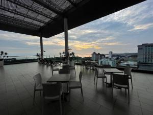 a patio with tables and chairs on a roof at Melaka The Straits Residence in Malacca