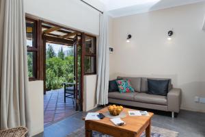 ein Wohnzimmer mit einem Sofa und einem Tisch in der Unterkunft Cederkloof Botanical Retreat in Citrusdal