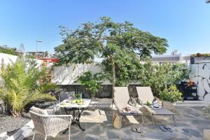 a patio with a table and chairs and a tree at Apartment La Maresia CB9A by VillaGranCanaria in San Agustin